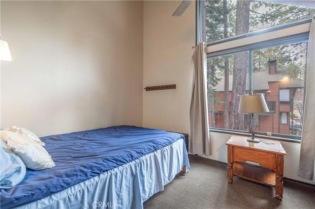 carpeted bedroom featuring ceiling fan and a towering ceiling