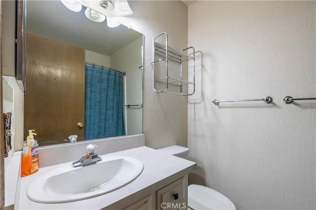 bathroom with a shower with curtain, vanity, and toilet