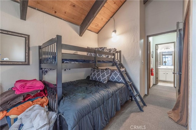 bedroom with vaulted ceiling with beams, wooden ceiling, carpet floors, and connected bathroom