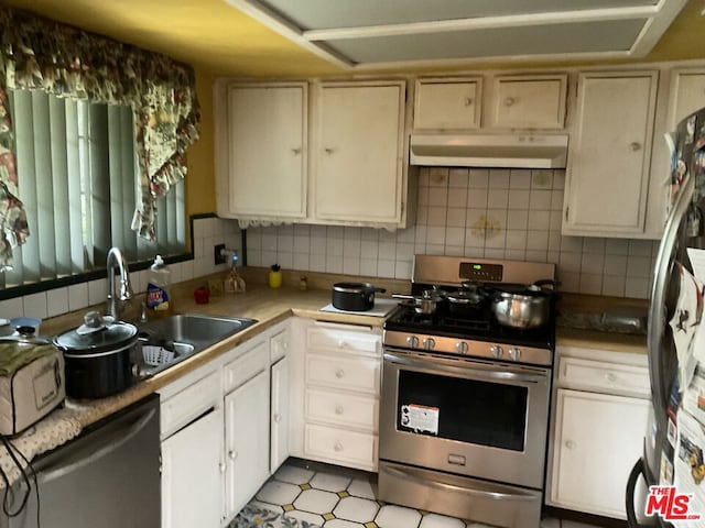 kitchen featuring decorative backsplash, appliances with stainless steel finishes, cream cabinets, and sink