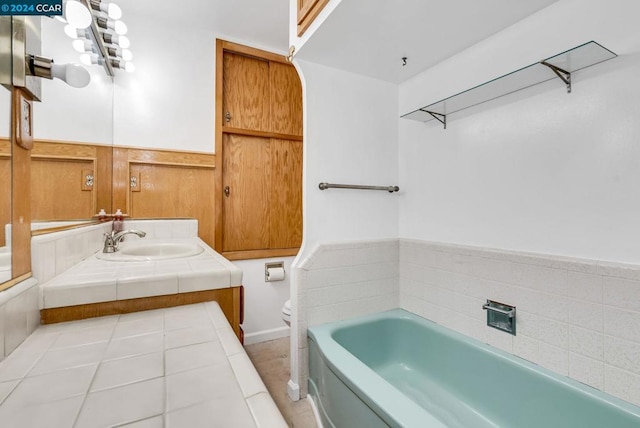 bathroom featuring tile patterned floors, a washtub, toilet, and vanity