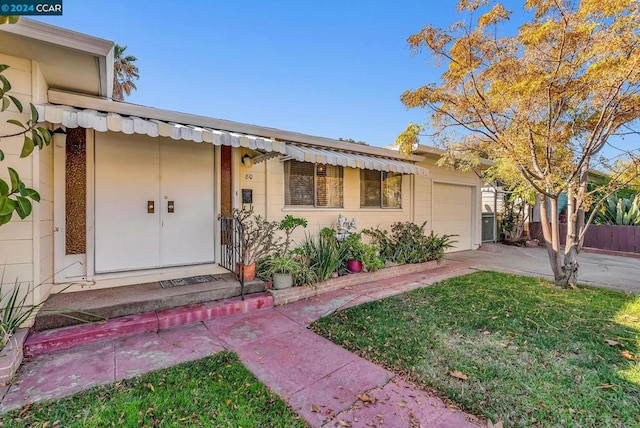 doorway to property featuring a lawn and a garage