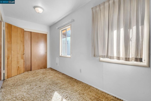 unfurnished bedroom with carpet and a closet