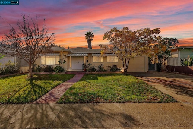 view of front of home featuring a lawn and a garage