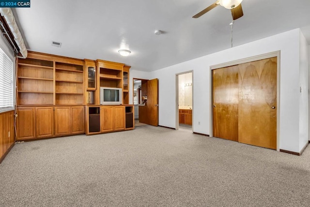 unfurnished living room featuring light carpet and ceiling fan