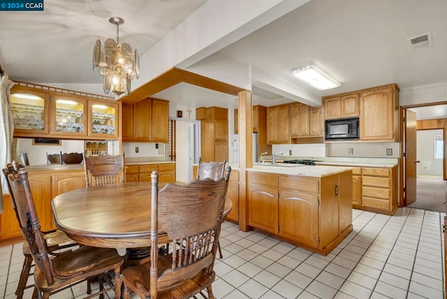 kitchen with pendant lighting, an inviting chandelier, light tile patterned floors, kitchen peninsula, and black microwave