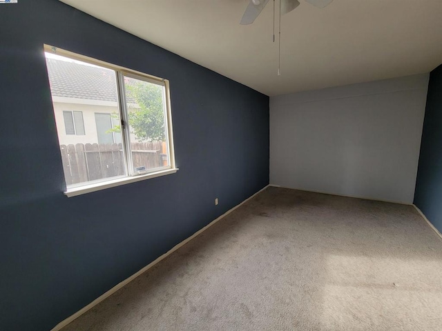 empty room with ceiling fan and carpet flooring