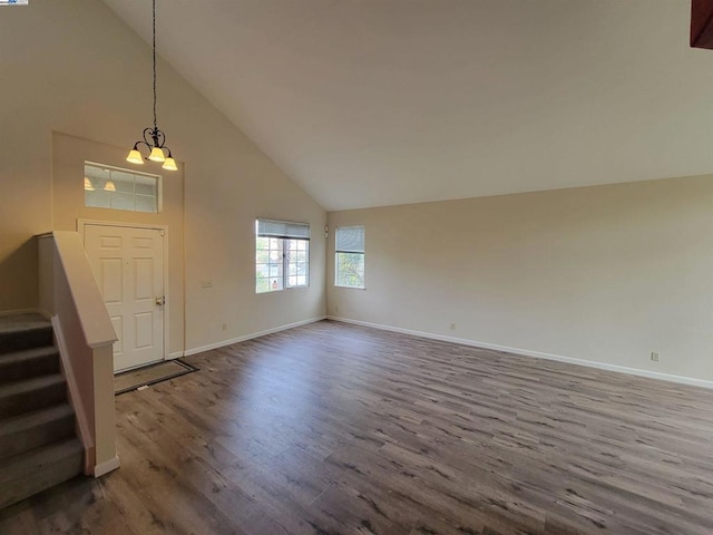 entrance foyer featuring high vaulted ceiling, wood-type flooring, and a chandelier