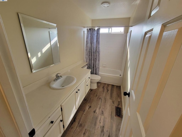 full bathroom featuring toilet, shower / bath combo, hardwood / wood-style flooring, and vanity