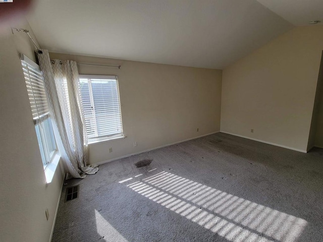 carpeted empty room featuring lofted ceiling