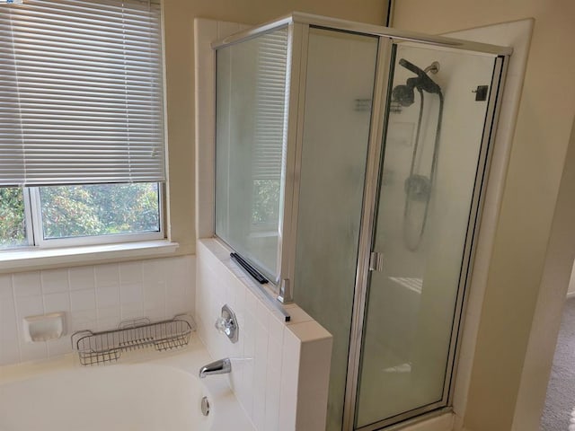 bathroom featuring shower with separate bathtub