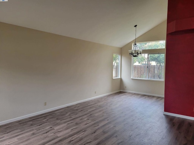 unfurnished dining area featuring hardwood / wood-style flooring, high vaulted ceiling, and a chandelier