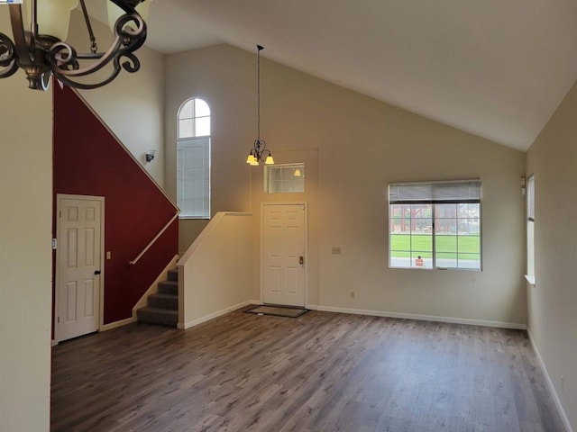 foyer entrance with a chandelier, hardwood / wood-style flooring, and high vaulted ceiling