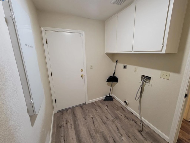 laundry area with light hardwood / wood-style flooring, hookup for an electric dryer, hookup for a washing machine, and cabinets