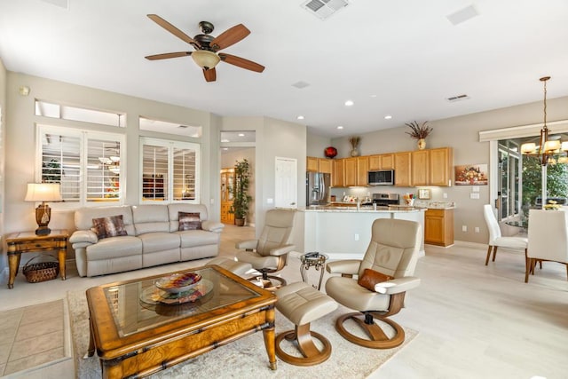 living room featuring ceiling fan with notable chandelier