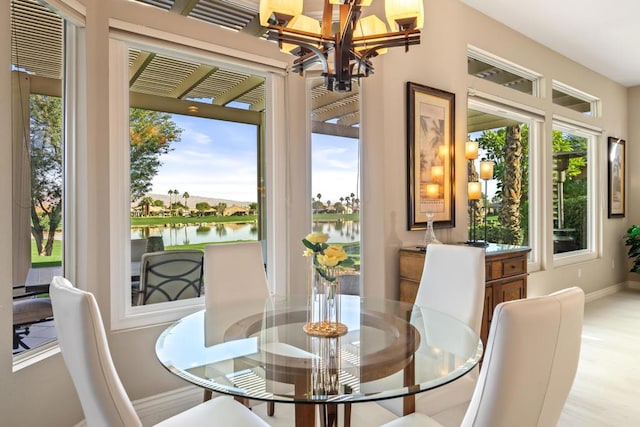 dining space with a water view and a notable chandelier