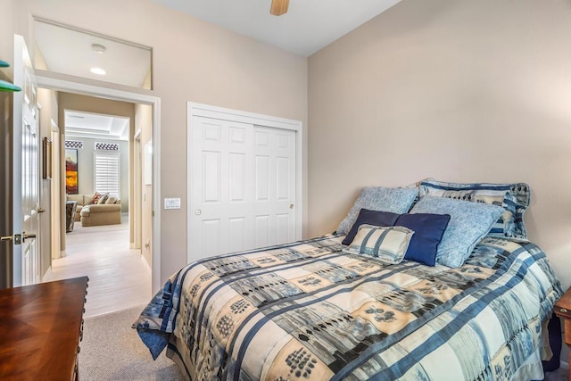 carpeted bedroom with ceiling fan and a closet