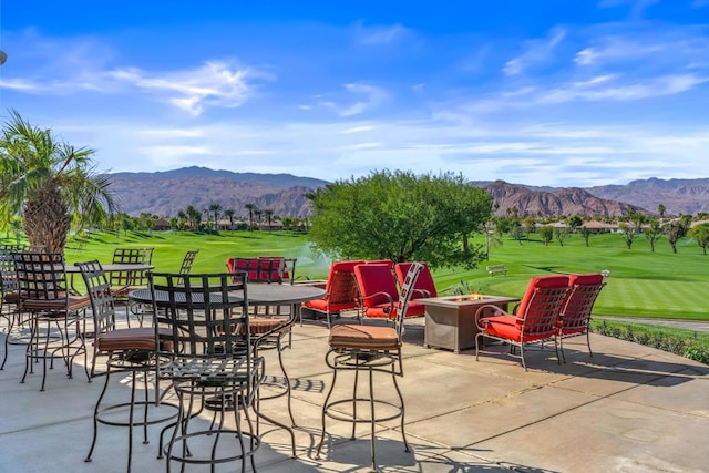 view of patio / terrace with a mountain view and a fire pit