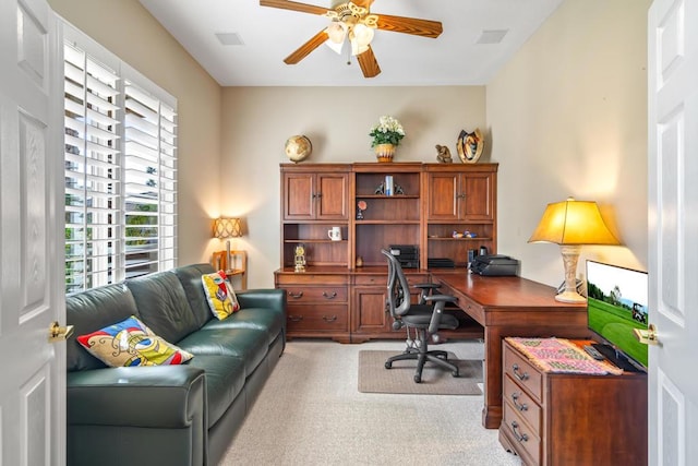 carpeted home office featuring ceiling fan