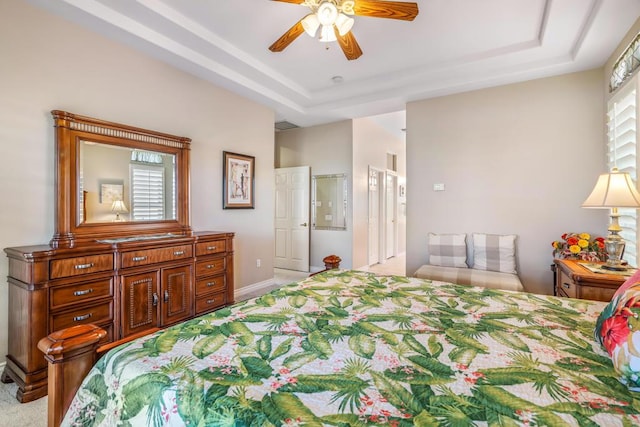 bedroom with a tray ceiling, multiple windows, and ceiling fan