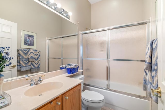 full bathroom with vanity, bath / shower combo with glass door, and toilet