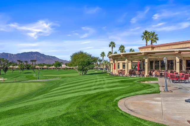 view of property's community featuring a lawn and a mountain view