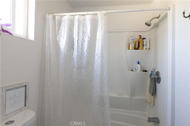 bathroom with shower / bath combo and toilet