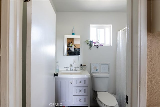 bathroom featuring a shower with curtain, vanity, and toilet