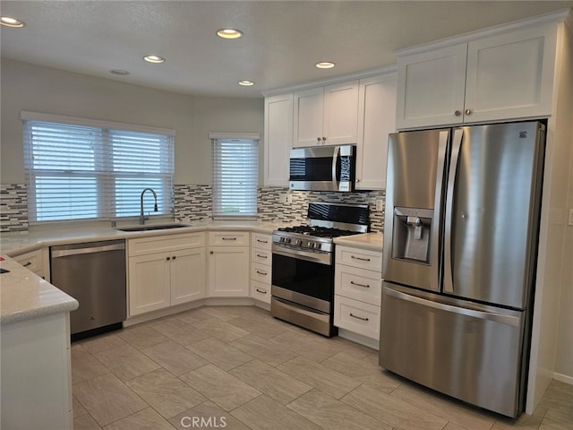 kitchen with white cabinets, a healthy amount of sunlight, sink, and stainless steel appliances