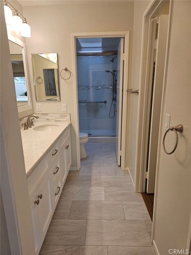 bathroom with vanity, toilet, and an enclosed shower