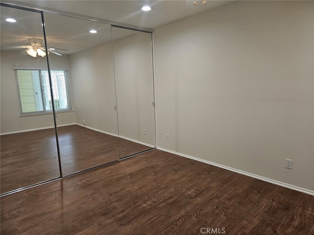 unfurnished bedroom with a closet, ceiling fan, and dark hardwood / wood-style flooring