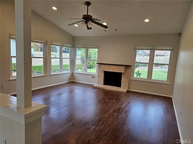 unfurnished living room featuring a tiled fireplace, ceiling fan, dark hardwood / wood-style flooring, and vaulted ceiling