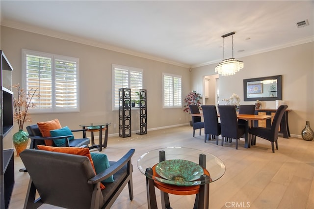 living room featuring a wealth of natural light, ornamental molding, and light wood-type flooring