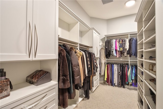 walk in closet featuring light colored carpet