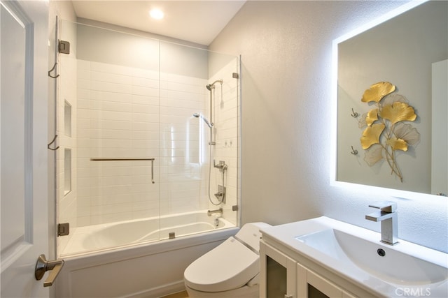 full bathroom featuring vanity, tiled shower / bath combo, and toilet