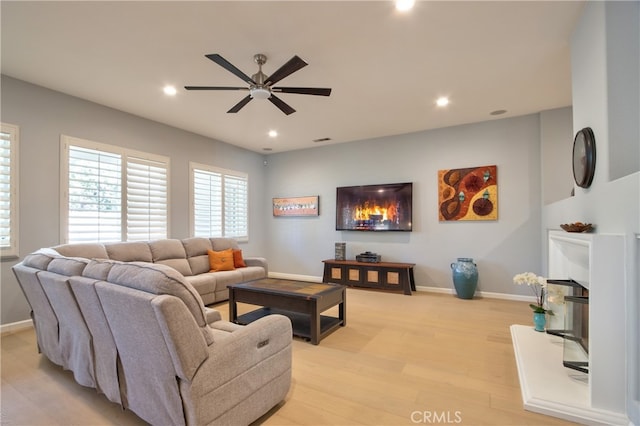 living room with ceiling fan and light wood-type flooring