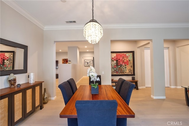 dining area featuring light hardwood / wood-style flooring, an inviting chandelier, and ornamental molding