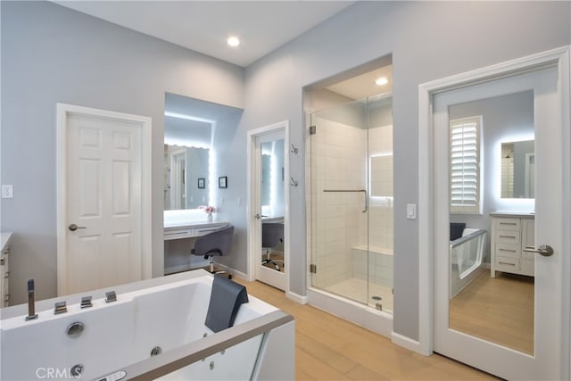 bathroom with wood-type flooring, vanity, and a shower with door