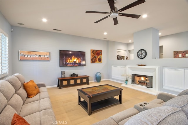 living room featuring light hardwood / wood-style floors and ceiling fan