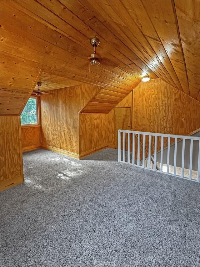 additional living space with wood ceiling, lofted ceiling, carpet floors, and wood walls