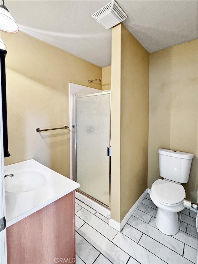 bathroom featuring vanity, toilet, and a shower with door