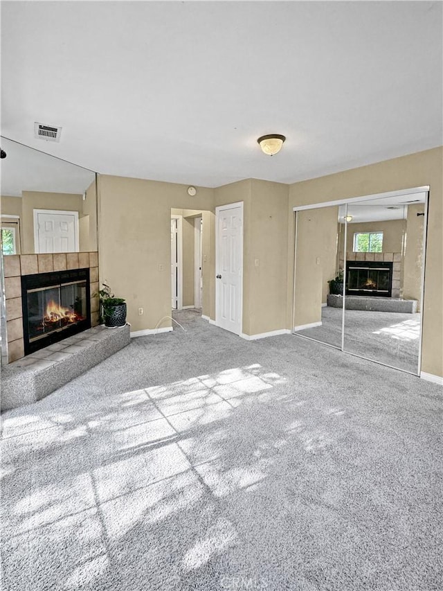 unfurnished living room featuring carpet flooring and a fireplace