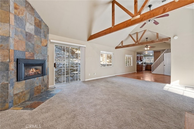 unfurnished living room featuring beam ceiling, dark colored carpet, a fireplace, and high vaulted ceiling