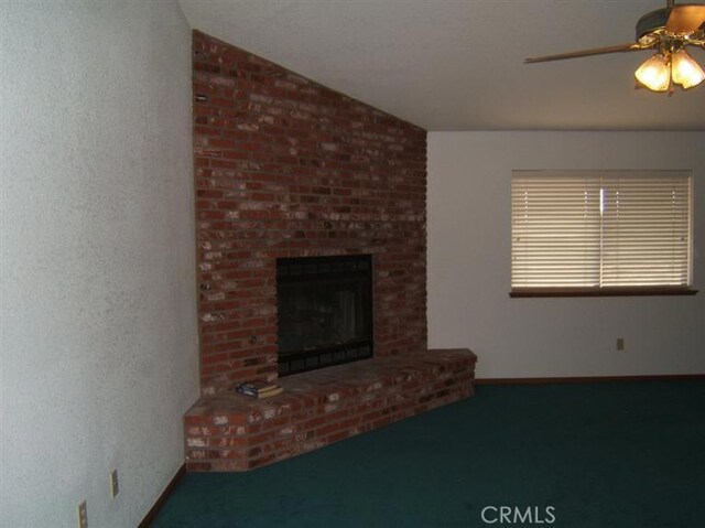 unfurnished living room with a brick fireplace, ceiling fan, and vaulted ceiling