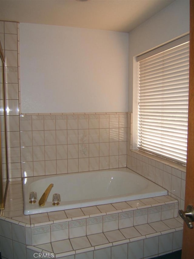 bathroom with a relaxing tiled tub