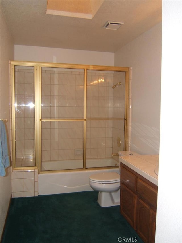 full bathroom featuring toilet, combined bath / shower with glass door, and vanity