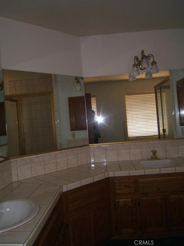 bathroom with decorative backsplash, vanity, and a shower with door