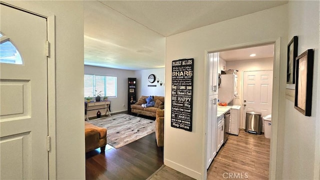 hall with light wood-style flooring and baseboards