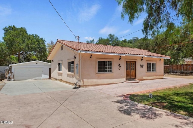 mediterranean / spanish house featuring a garage and an outbuilding