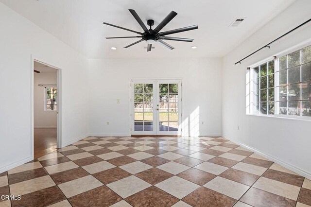 spare room with french doors, a healthy amount of sunlight, and baseboards